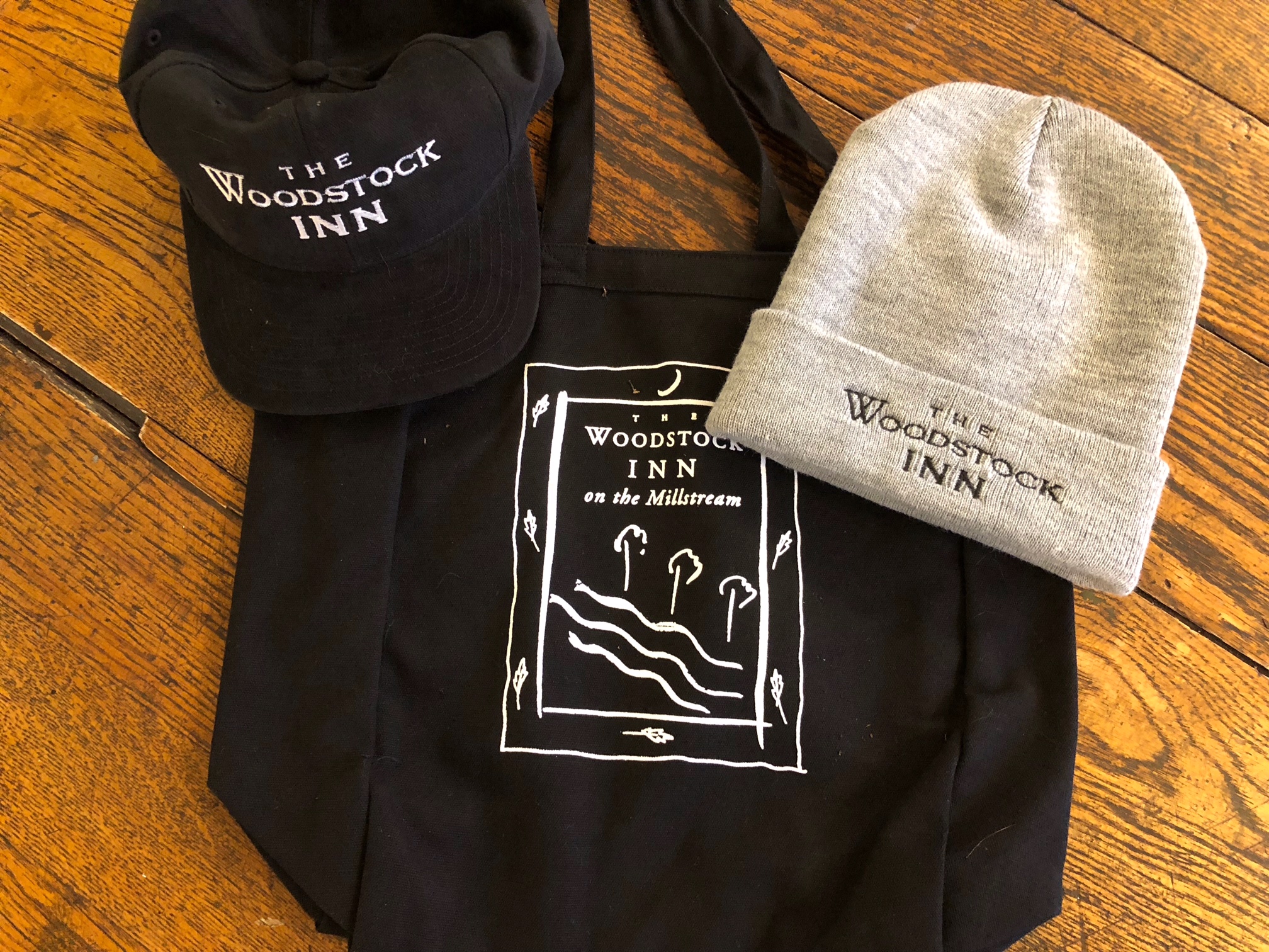 a hat, baseball cap and tote - all with the woodstock inn's logo on it.